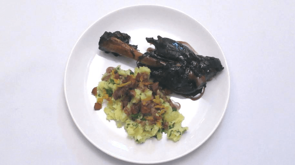 Jehněčí kolínko na červeném víně, šťouchané brambory s rukolou a parmezánem